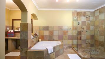 A bathroom with a bathtub, shower, and a vanity with a sink.