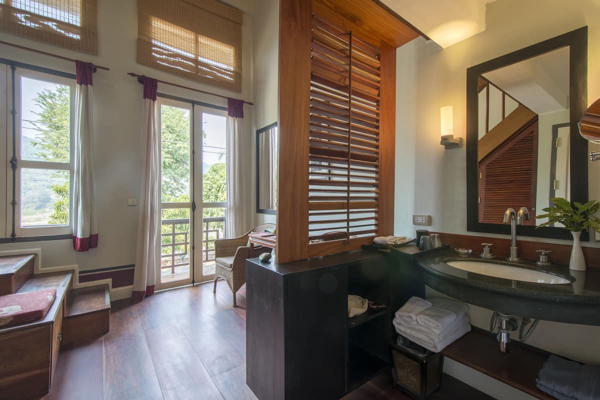 A bathroom with a wooden vanity, a large mirror, and a sink.