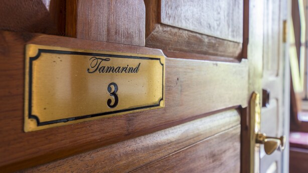 A brass nameplate with the name "Tamarind" and the number "3" on a wooden door. - The Belle Rive Boutique Hotel (Luang Prabang)