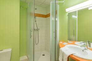 A bathroom with a glass-enclosed shower, a white sink, and an orange countertop. - Pressoir Hôtel (Saint-Calais)