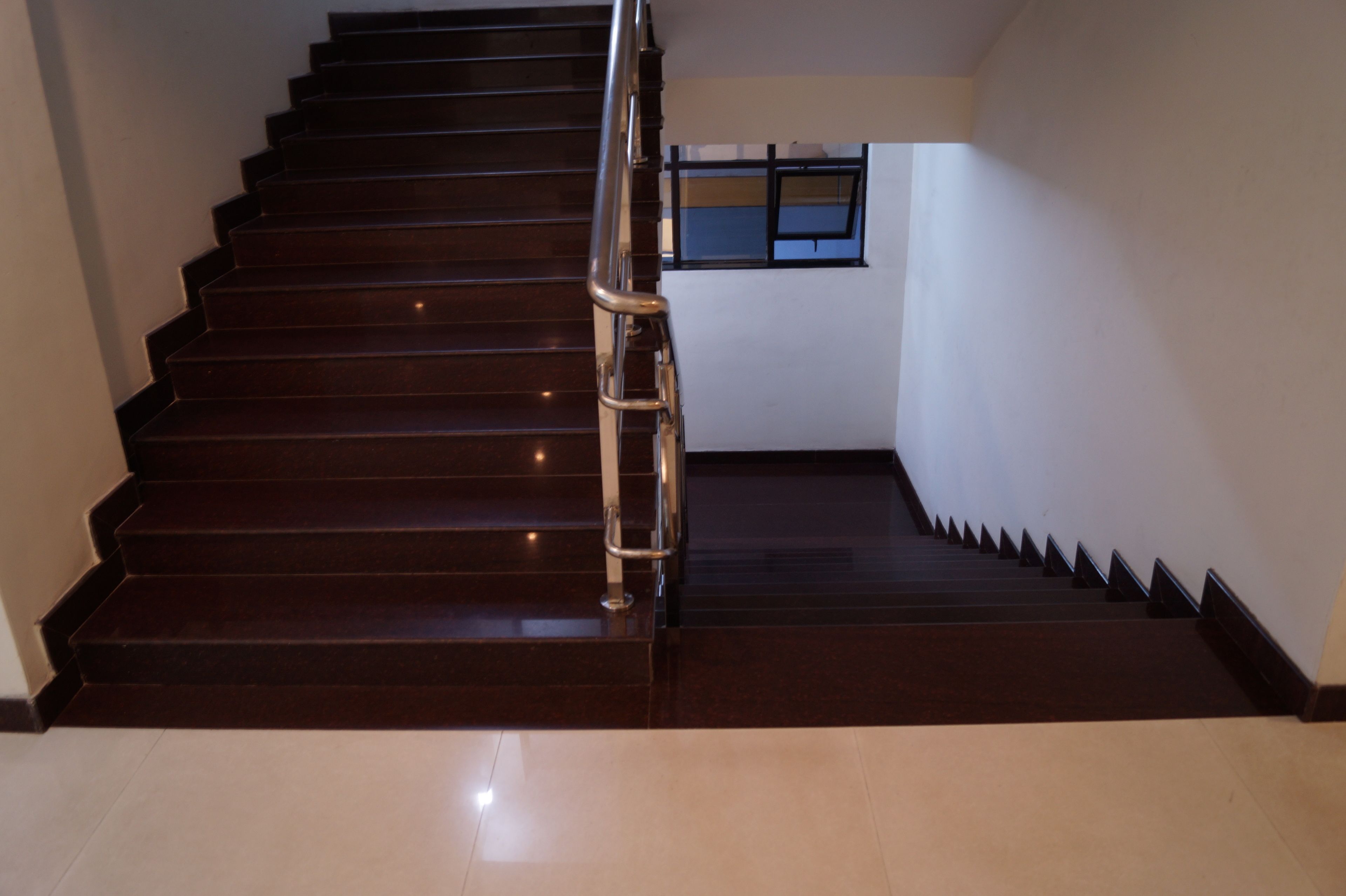 A staircase with dark wooden steps and a metal handrail.