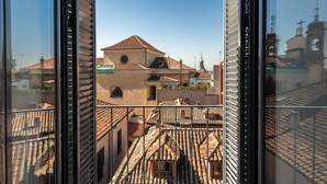 A view from a window overlooking a building with terracotta tiled roofs and a bell tower. - SmartRental Madrid Puerta del Sol (Madrid)