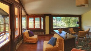 Ein gemütliches Wohnzimmer mit Kamin, Bücherregal und Blick ins Grüne.
