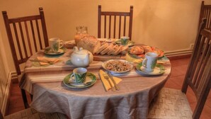 Ein runder Esstisch mit Stoffauflage, umgeben von Holzsesseln.