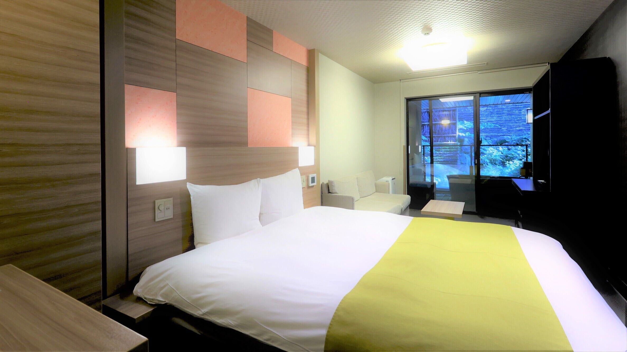 Ein Hotelzimmer mit Bett, Nachttischen, Schreibtisch, Stuhl, Fernseher und einem Fenster mit Blick.