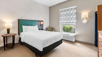 Een hotelkamer met een bed, nachtlampjes, een raam met uitzicht en een radiator.