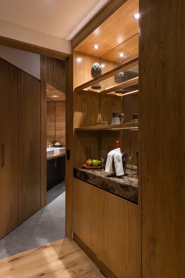 Une cuisine moderne avec des meubles en bois, un plan de travail en marbre et un meuble à vin intégré.