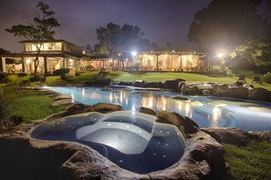 Een buitenzwembad, parasols bij het zwembad en ligstoelen