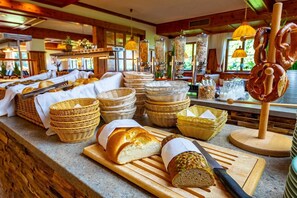 A buffet setup with various breads and baskets. - Erlebnis Hotel Chiemgauer Hof (Inzell)