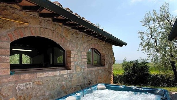 Un edificio de piedra con un jacuzzi en primer plano.