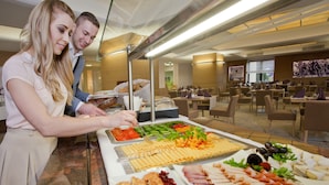 Un buffet proposant une variété de plats et un espace de restauration avec des tables et des chaises.