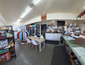 A retail store with a checkout counter, shelves stocked with products, and a refrigerator. - Van Riper's Resort (Sekiu)