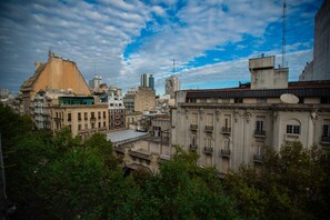 Un paisaje urbano con varios edificios, incluyendo una construcción destacada con una forma de techo peculiar y otra con una antena parabólica.