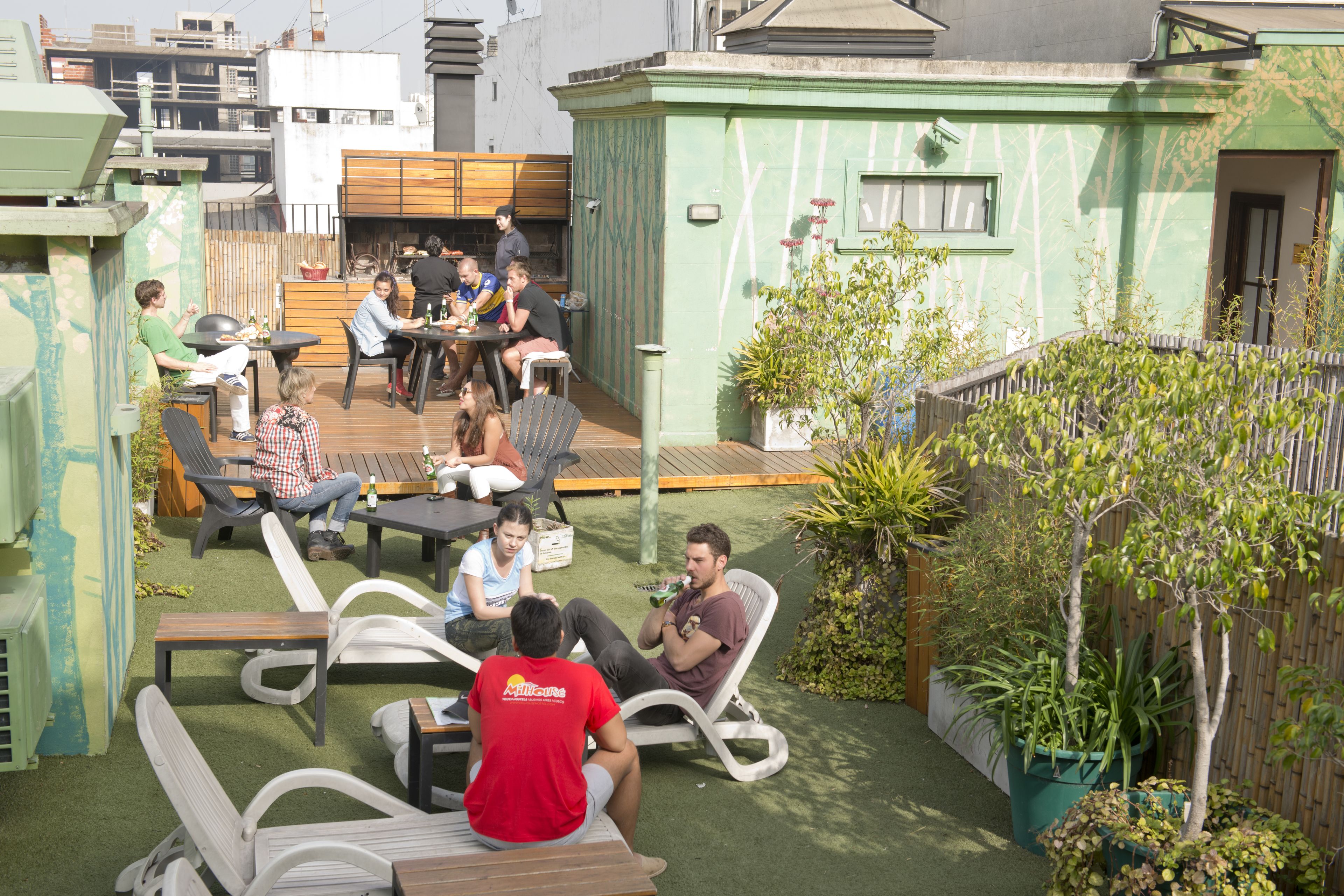 An outdoor patio area with lounge chairs, a dining table, and a small garden.