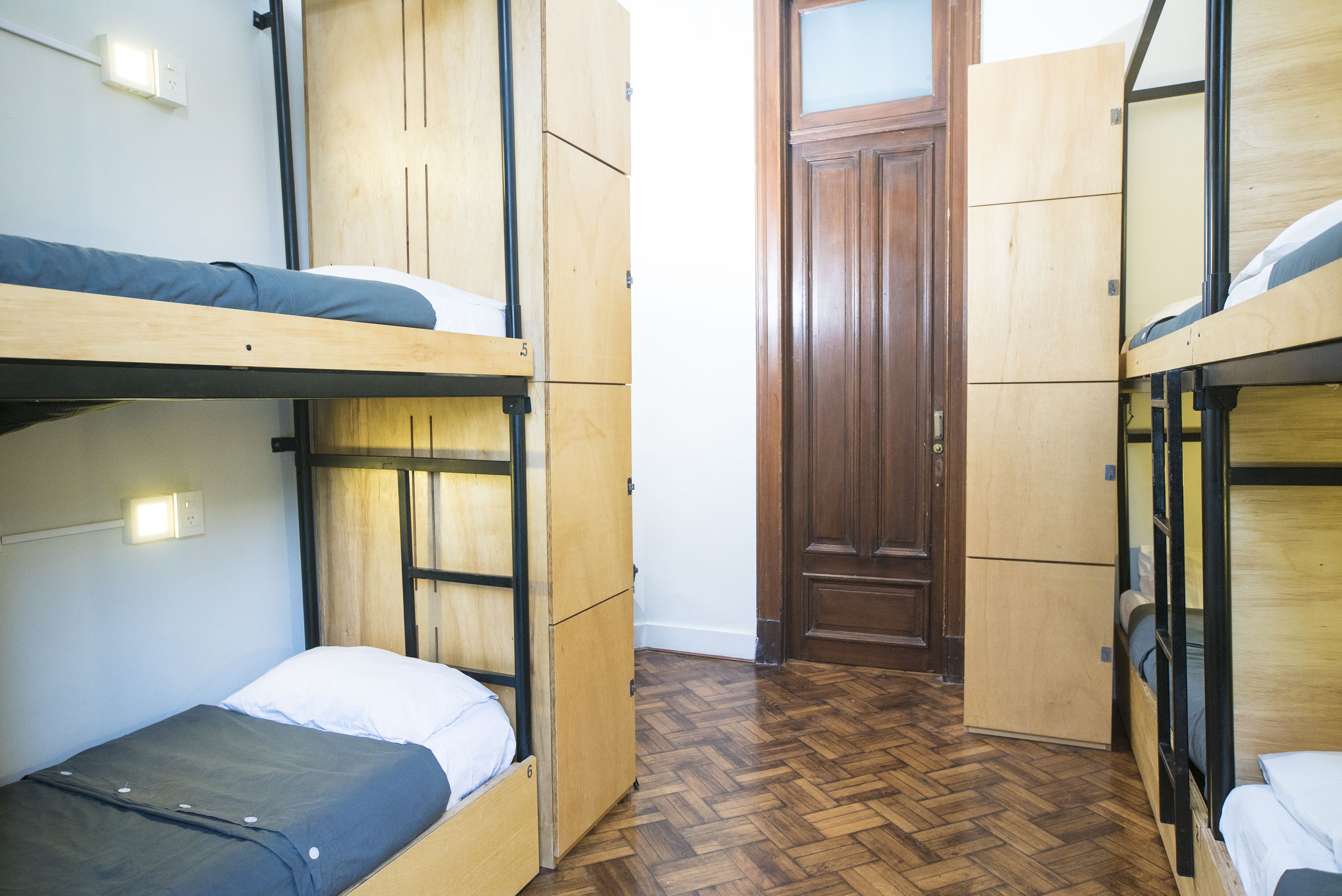 Una camera del dormitorio con letti a castello, pareti e porta in legno.