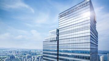 A modern high-rise hotel with a glass facade and the name 'Park Hyatt' on the top.