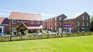 A hotel with a brick facade, a wooden fence, and a sign indicating it's open. - Premier Inn Farnham (Farnham)