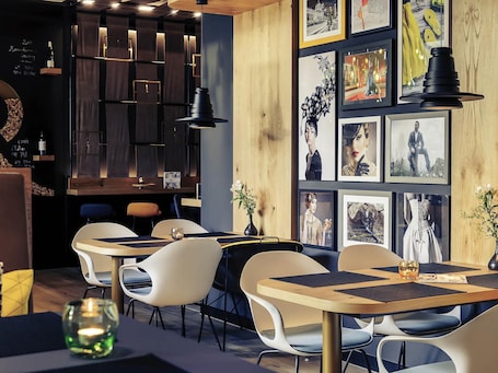 A modern restaurant interior with wooden accents, contemporary furniture, and framed artwork on the walls.