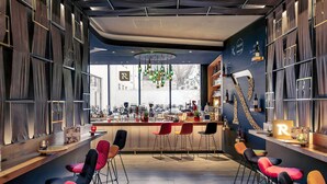 Un espace bar avec des tabourets, un comptoir et une vue sur l’extérieur.