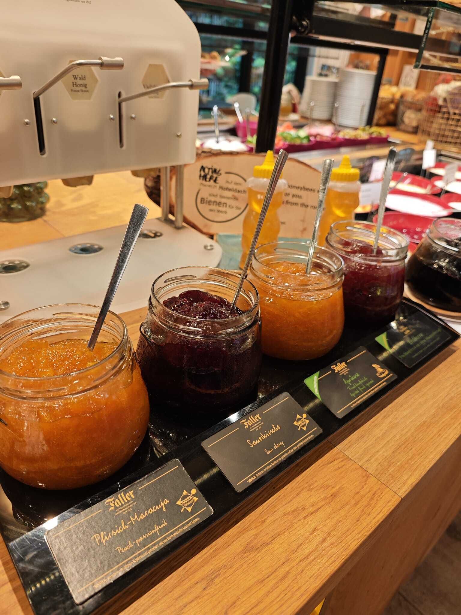 Variedad de mermeladas y salsas con etiquetas que indican sabores como melocotón y ciruela.