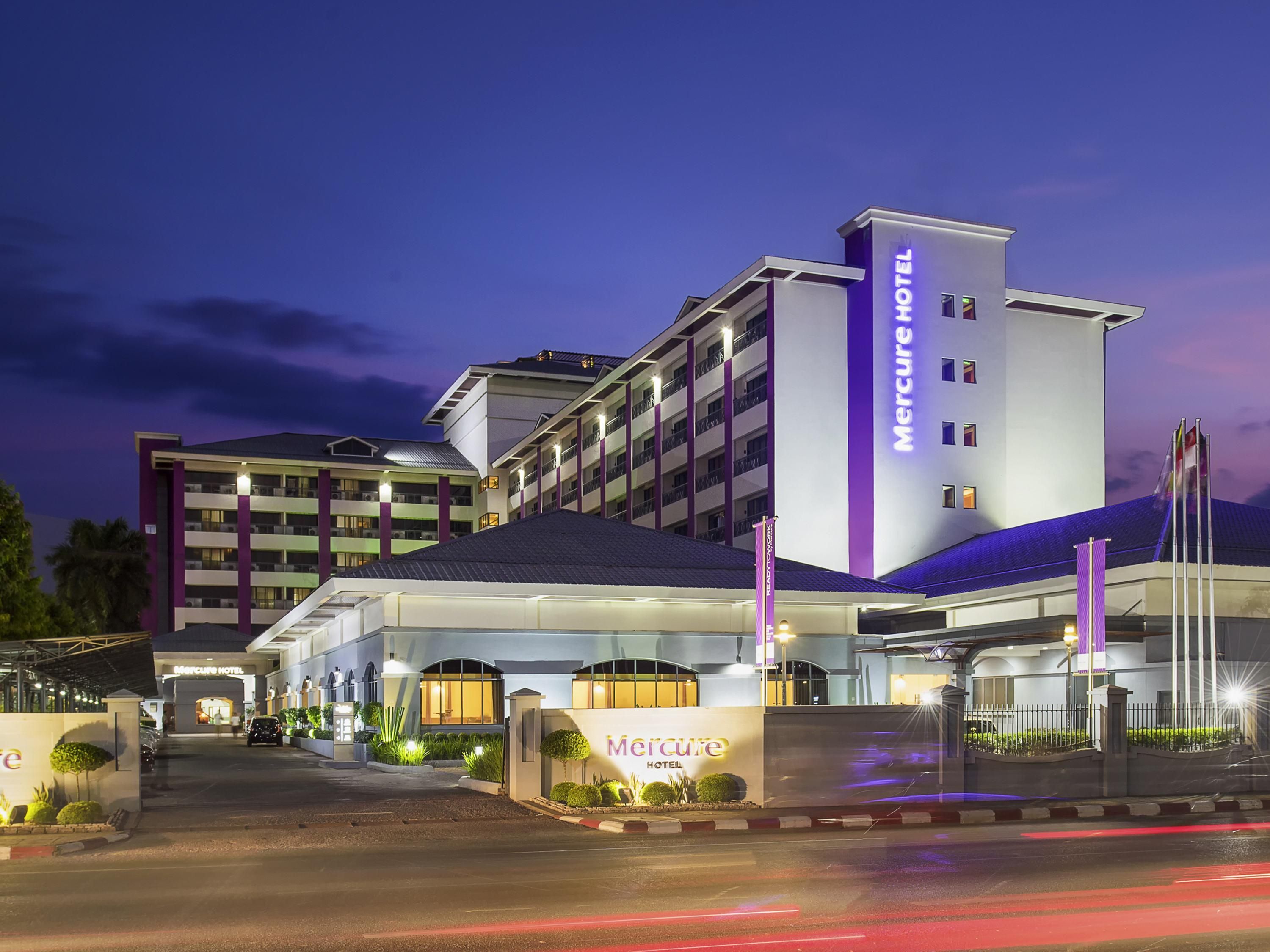 Un hotel con una entrada destacada, varios pisos y una fachada bien iluminada.