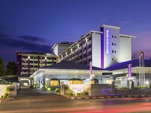 Un hotel con una entrada destacada, varios pisos y una fachada bien iluminada.