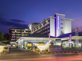 Un hotel con una entrada destacada, varios pisos y una fachada bien iluminada.