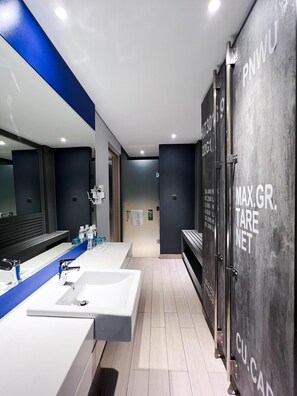 A modern bathroom with three sinks, a large mirror, and a towel rack. - Ibis Styles Batam Nagoya (Batam)