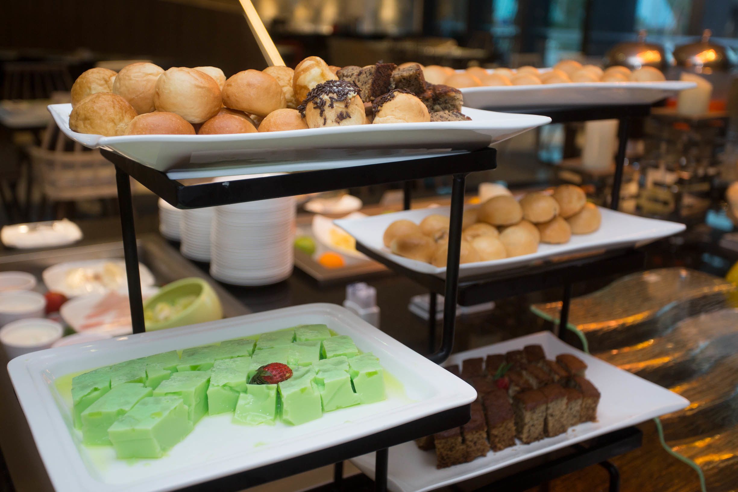 Un buffet proposant une variété de plats, notamment des viennoiseries, des gâteaux et des desserts.
