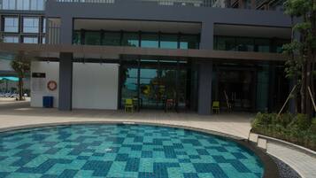 Un edificio moderno con piscina que destaca por un diseño de mosaicos azules y turquesa.