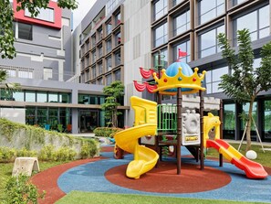 A playground with a slide, climbing structures, and a crown-shaped playhouse. - Ibis Styles Batam Nagoya (Batam)