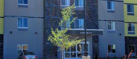 Een meerlaags hotel met een 'Days Inn & Suites' bord, duidelijke bewegwijzering en een parkeerplaats.