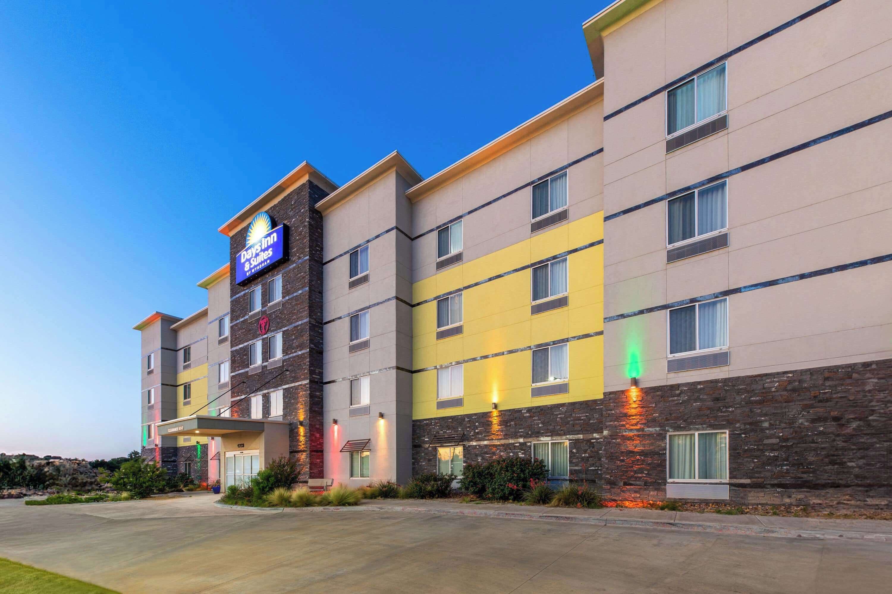 A multi-story hotel with a flat facade, a prominent Days Inn sign, and a landscaped entrance area.