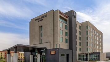 A modern hotel building with a prominent 'Doubleday' sign, multiple windows, and a gated entrance.