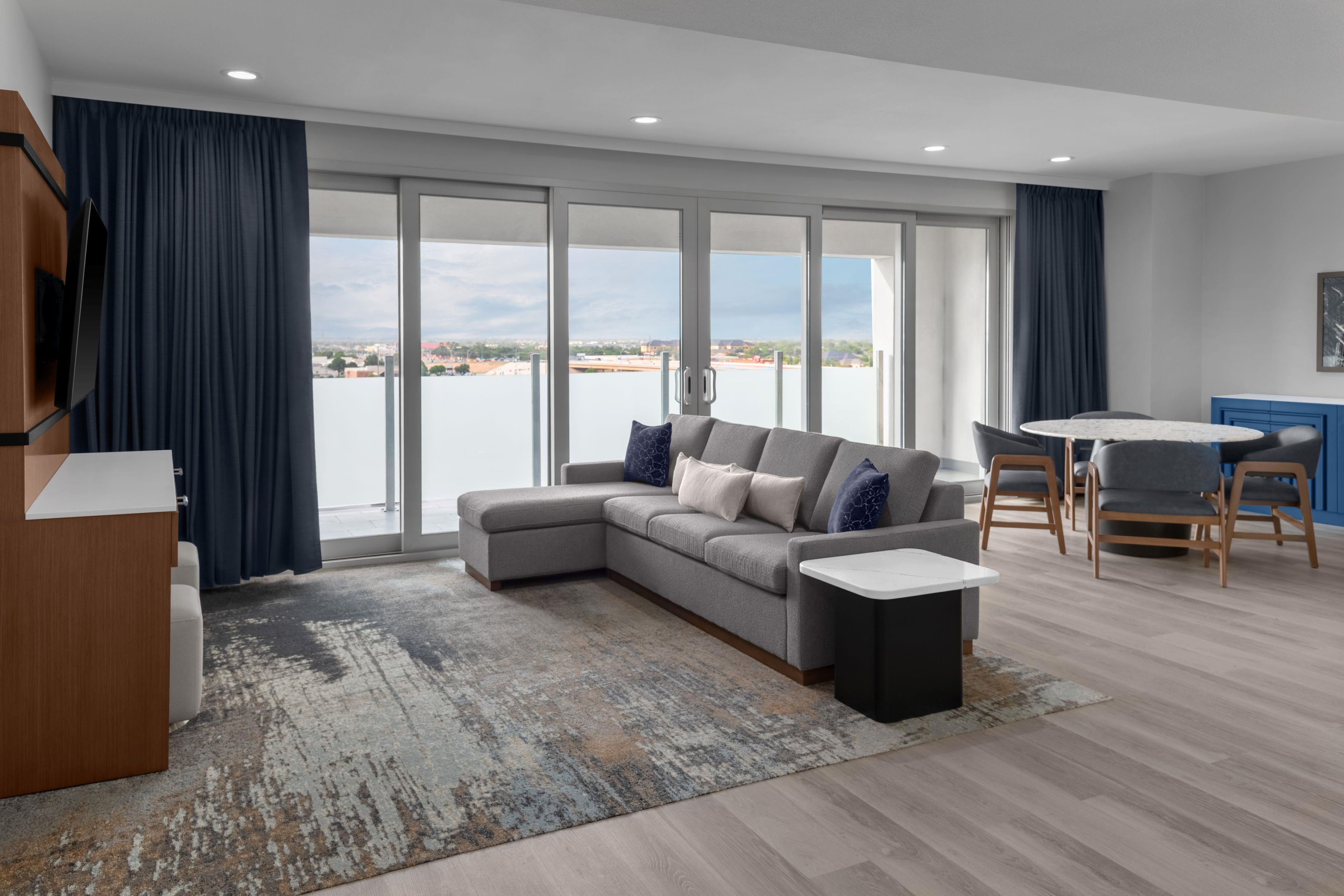 Una sala de estar moderna con un sofá seccional gris, una mesa de centro y vista al agua.
