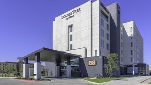 Un hotel moderno con ingresso facilmente accessibile, un'area di parcheggio coperta e un cartello con la scritta 'Bronco Blanco'.