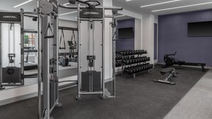 Una palestra con attrezzature per sollevamento pesi, manubri e macchinari cardio.