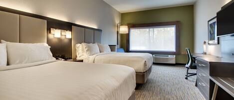 A hotel room with two beds, a desk, a chair, and a television.