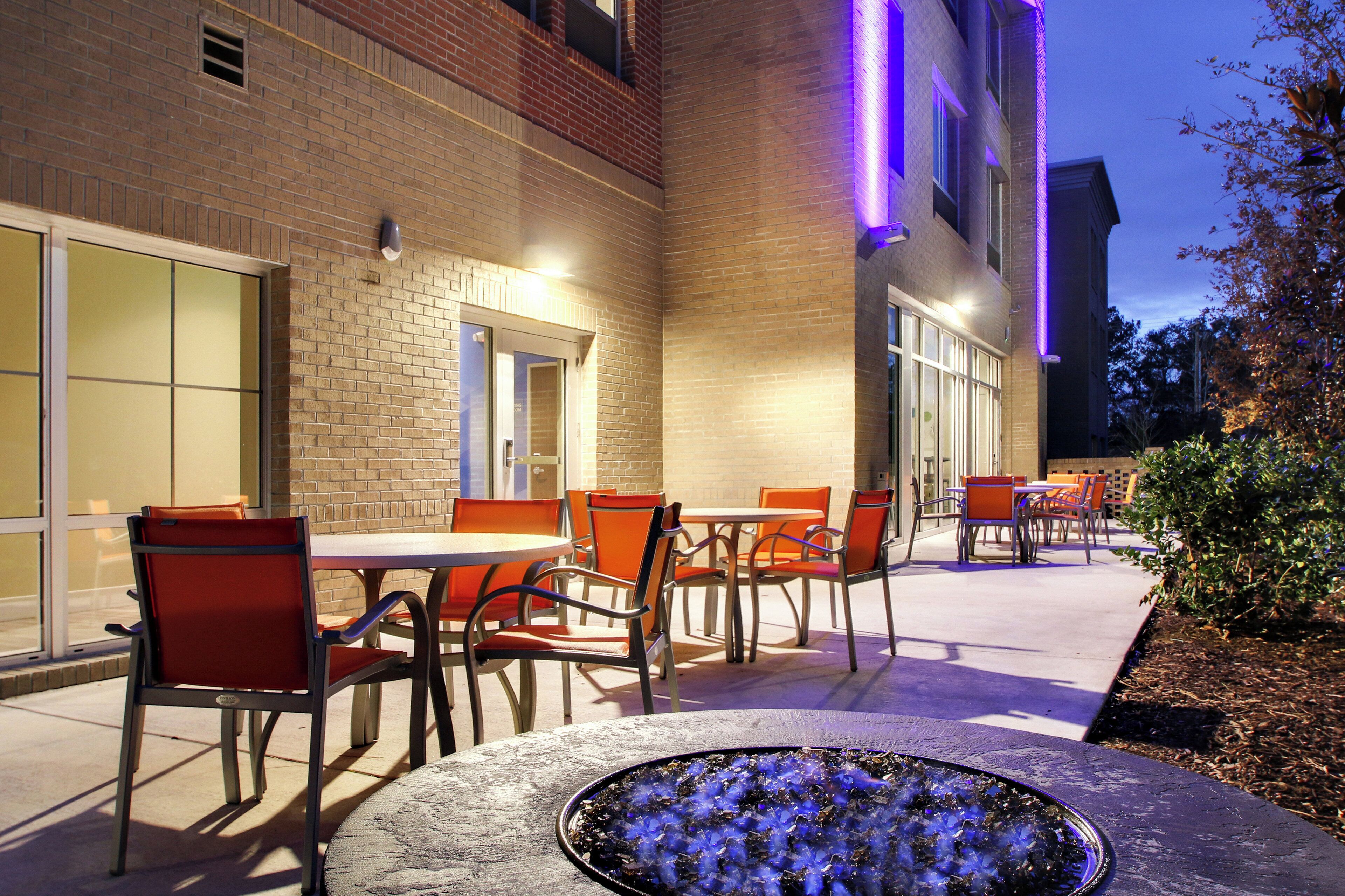 An outdoor patio area with brick walls, outdoor seating, and a fire feature.