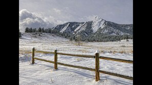 A snow-covered landscape with a wooden fence in the foreground and a mountain in the background. - Holiday Inn Express and Suites Broomfield by IHG (Broomfield)