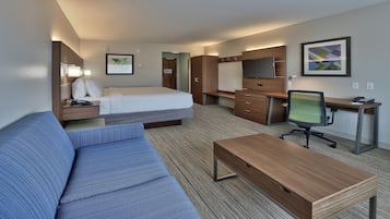 Een hotelkamer met een bed, een bureau, een stoel, een bank en een televisie.