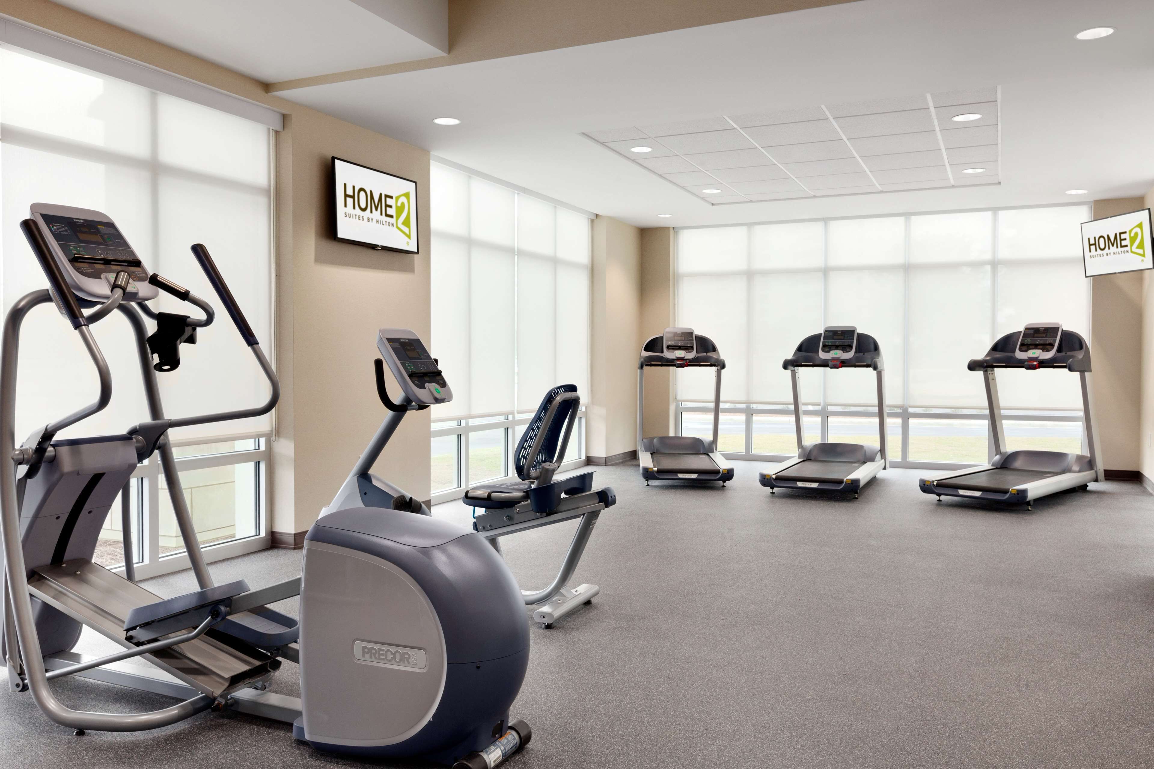 A gym with treadmills, ellipticals, and a stationary bike.