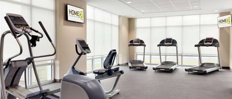 A gym with treadmills, ellipticals, and a stationary bike.