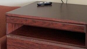 Ein TV-Schrank aus Holz, darüber ein Flachbildfernseher.