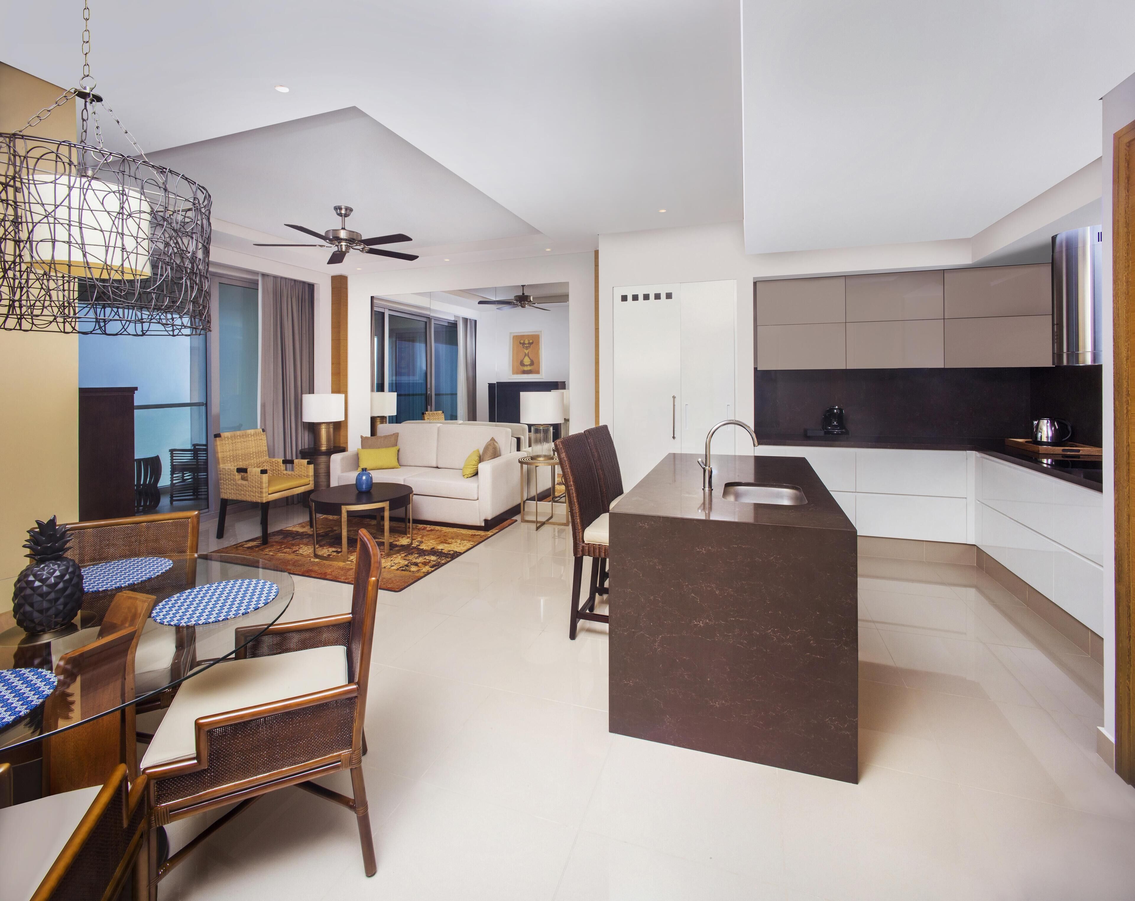 A modern apartment with a living room, dining area, and kitchen.