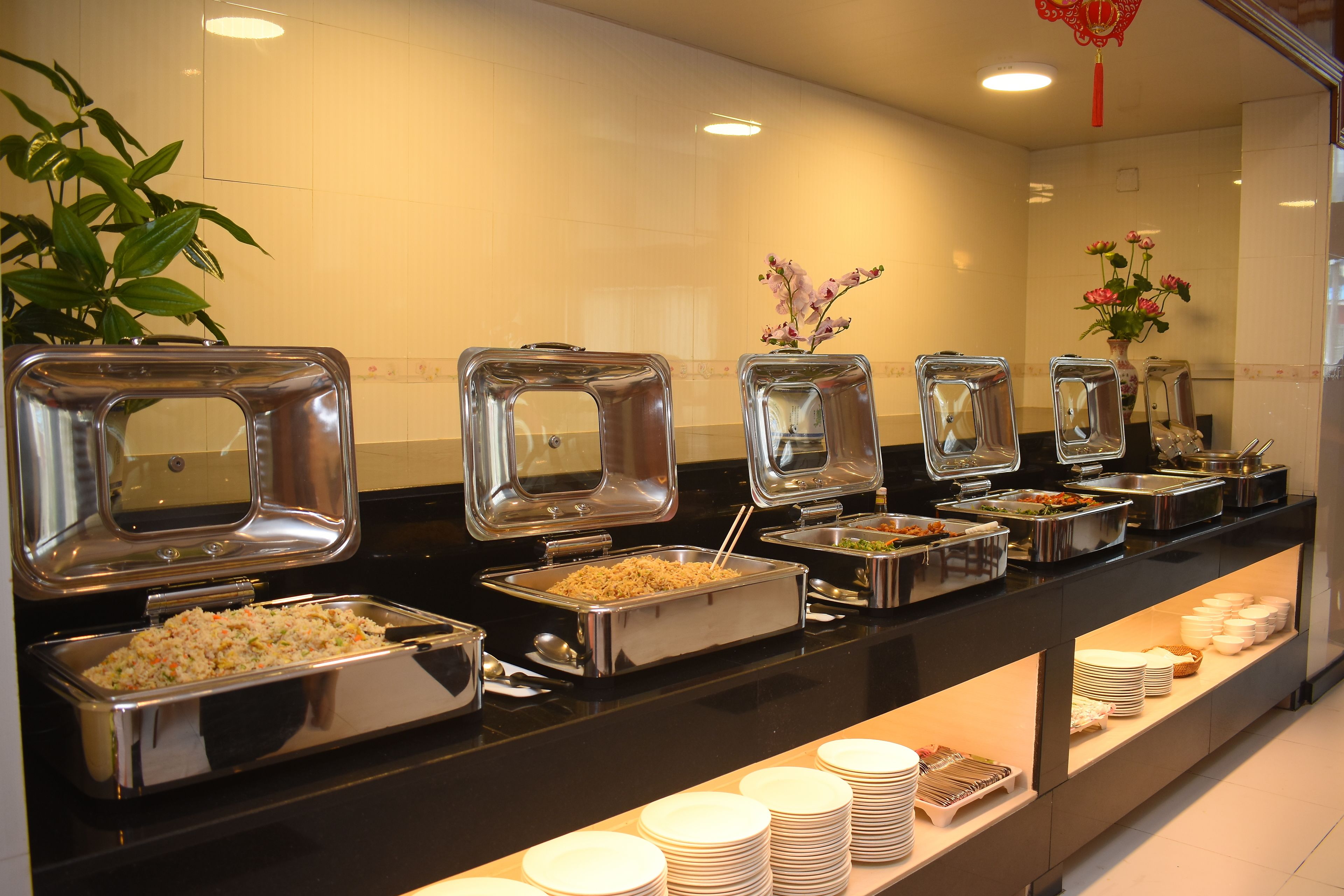 A buffet with various food options, including rice, vegetables, and meat dishes.