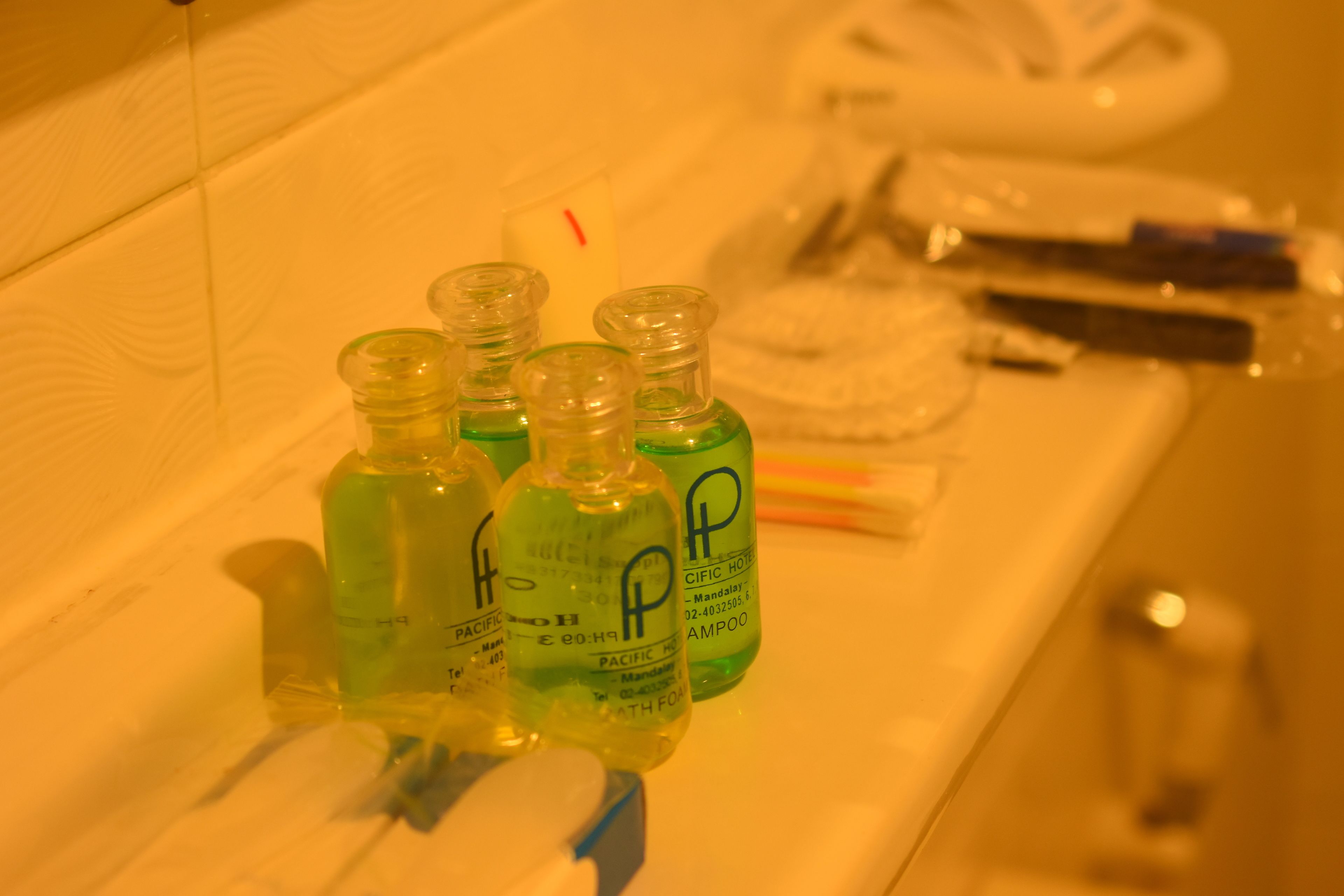 Bottles of Pacific Hotel shampoo and conditioner on a bathroom counter.