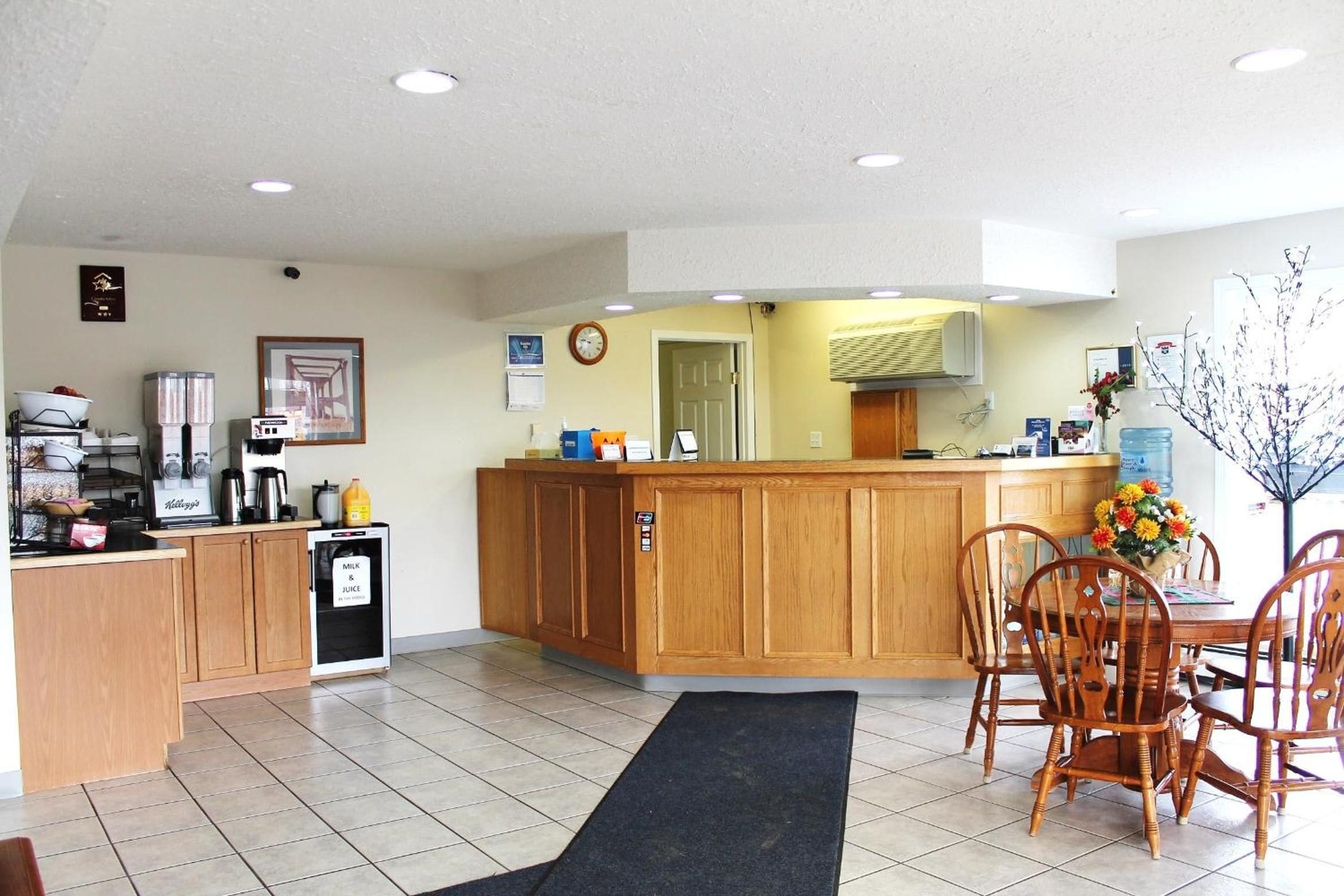 A compact kitchen with a refrigerator, coffee maker, and a small cabinet.