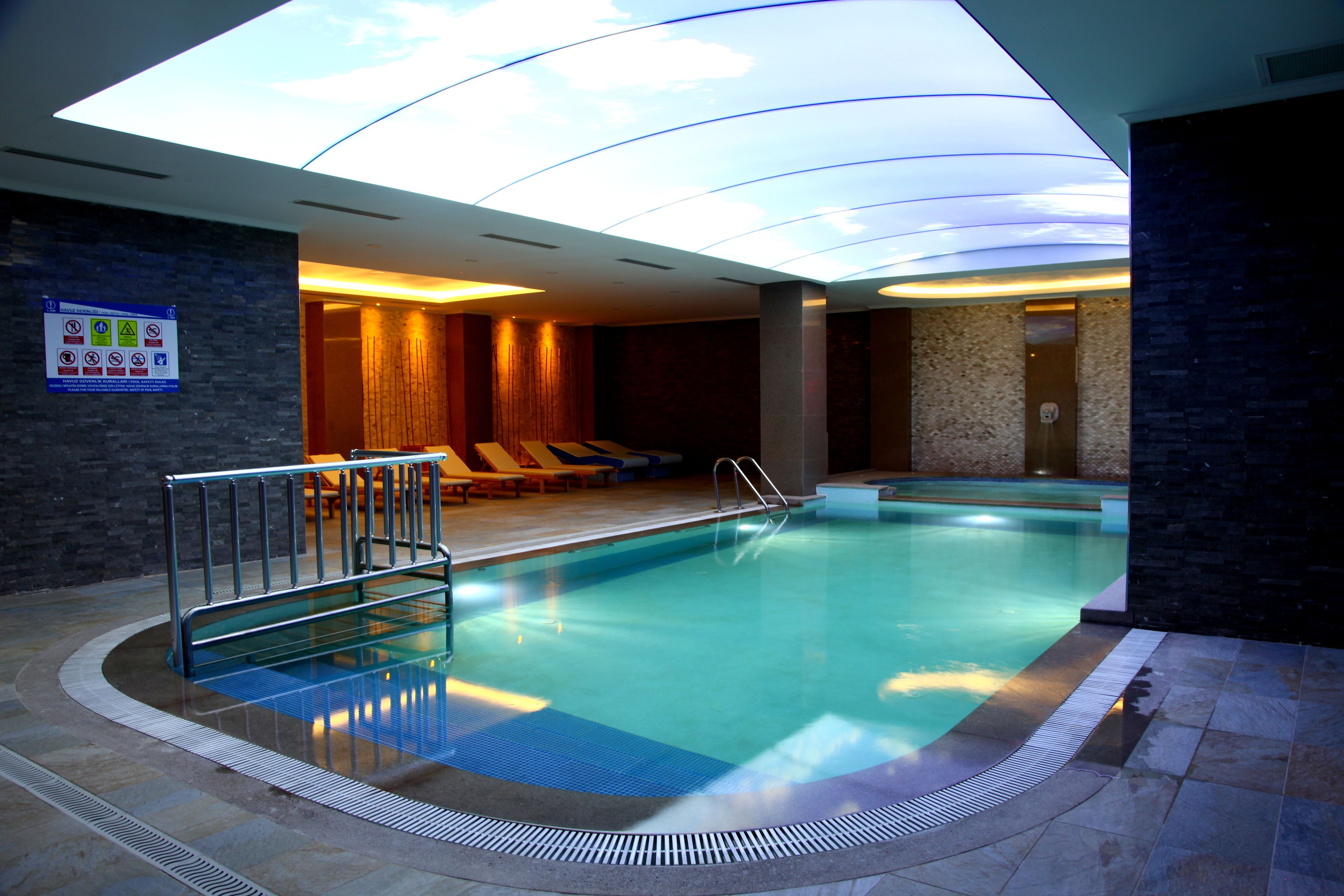 Una piscina cubierta, tumbonas