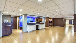 A spacious lobby with a reception desk, a blue decorative wall, and a wooden floor. - Fairfield Inn & Suites Springfield Holyoke (Holyoke)